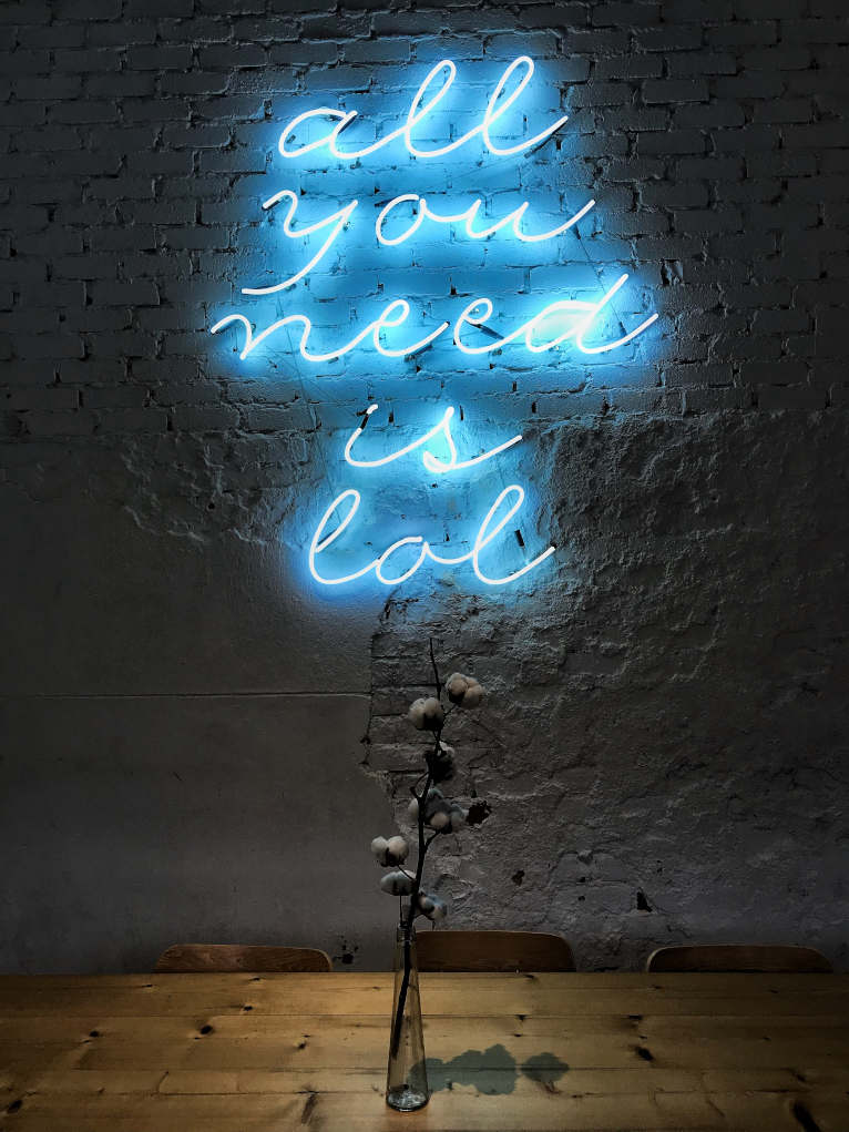 Lit up in blue neon are the words "all you need is lol".