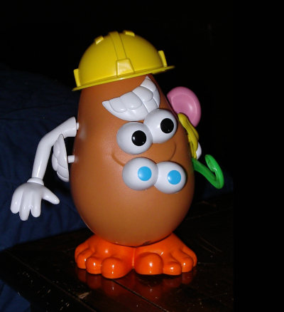 A Potato Head toy put together in a mixed-up way, with four eyes, two sets of teeth and other unusual choices.